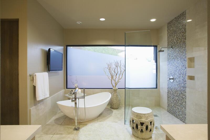 bathroom with tub and television